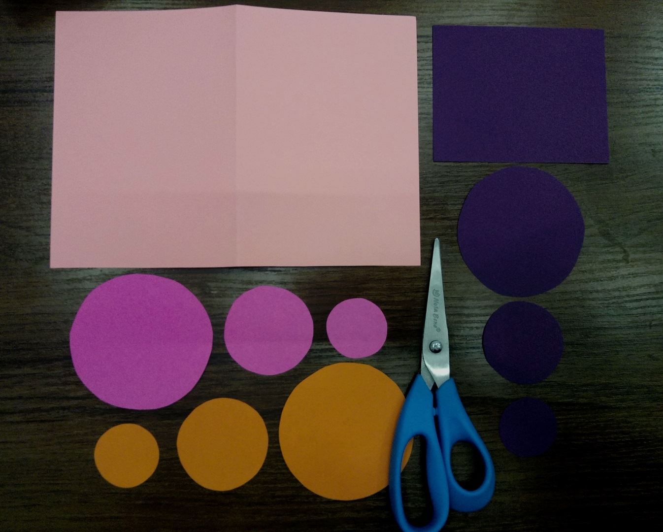 Из фиолетовой , сиреневой и оранжевой бумаги вырезаем по 3 кружка: по 1 большому, 1 среднему и 1 маленькому. Ещё вырезаем фиолетовый прямоугольник. Всё очень просто:)