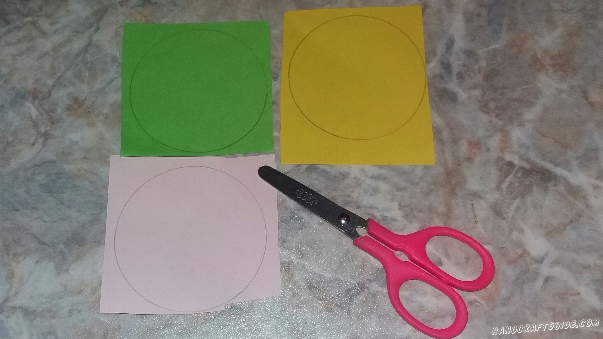 Для начала возьмем розовый, желтый и зеленый листы бумаги и нарисуем на них круги одинакового размера