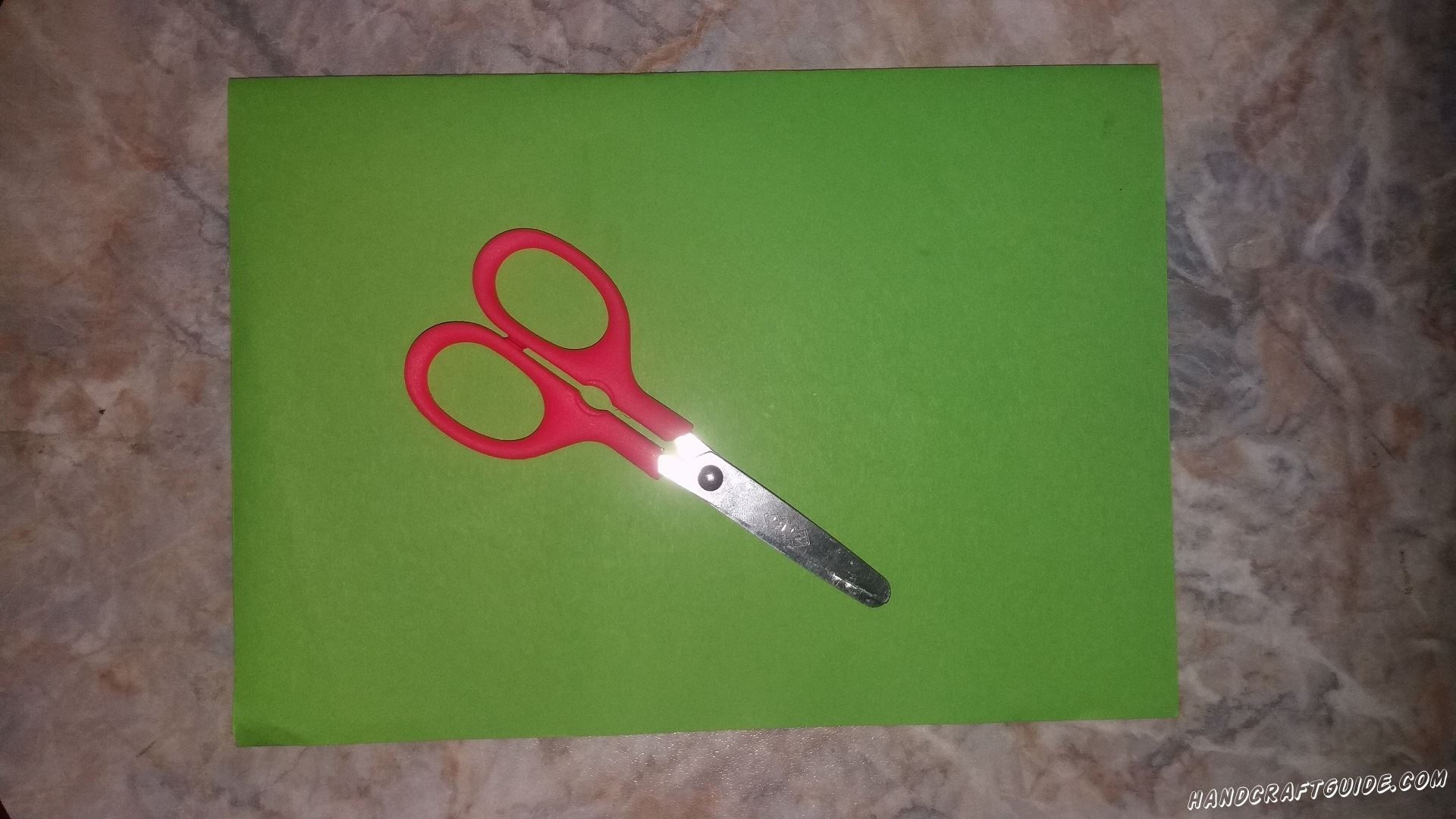 Из зелёного листа бумаги мы вырезаем большой треугольник.